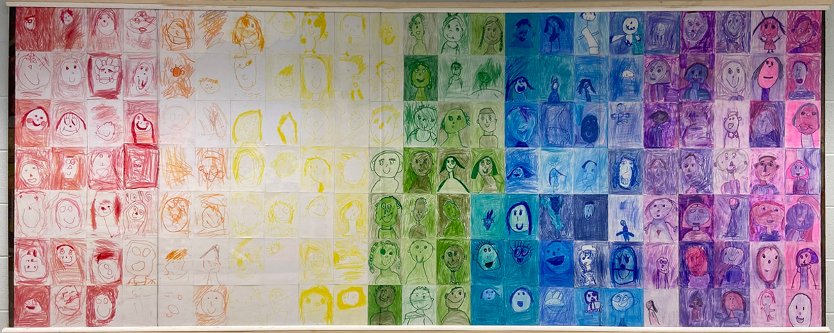 Photo of rainbow-colored mural of hand-drawn faces