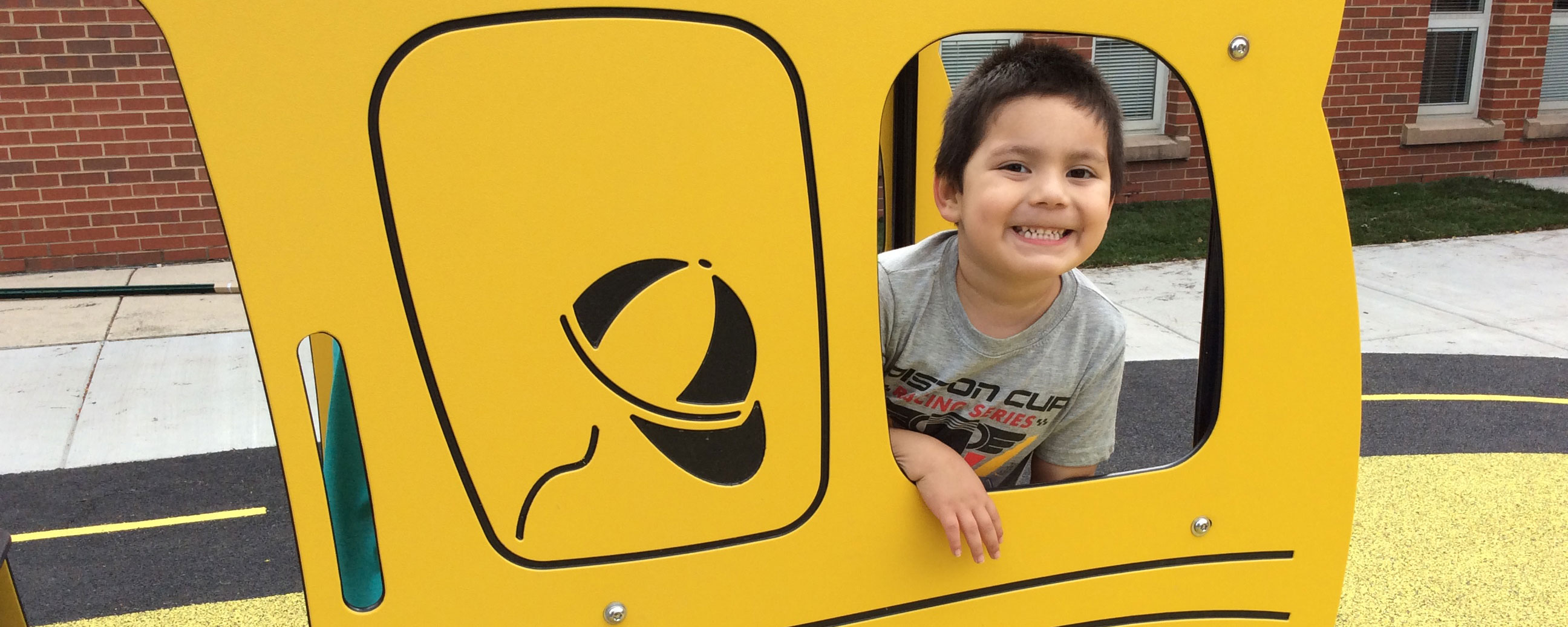 Photo of boy on playground schoolbus