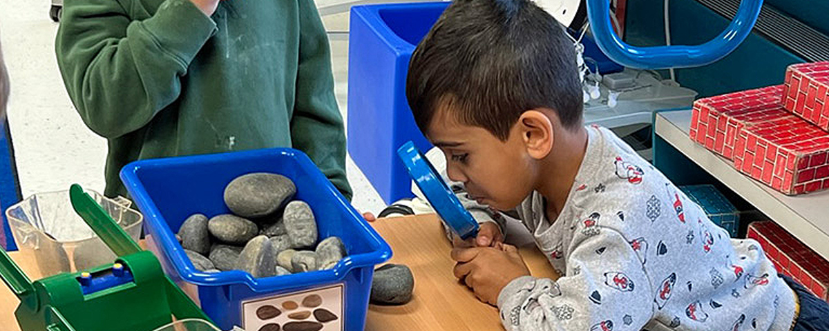 Meyer student explores rocks through a magnifying glass